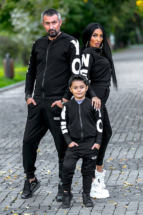 Black sports suit for girls/boys with white patches.