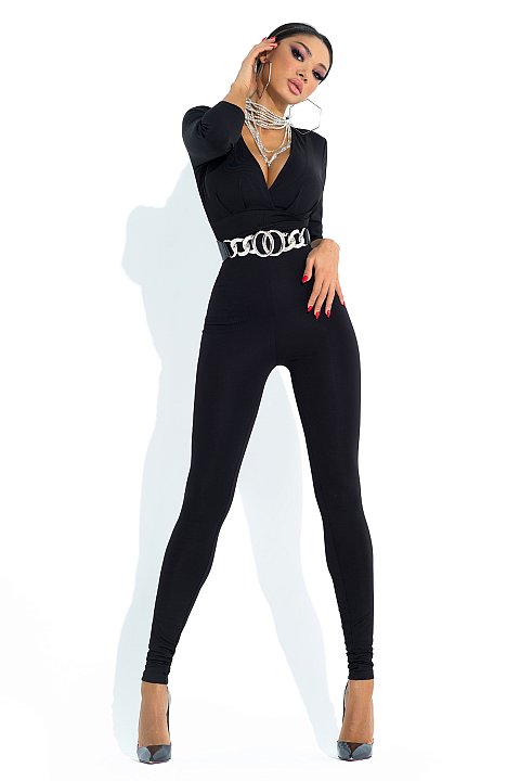 Black jumpsuit, modeled on the body. Deep V-neck with silver waist belt.