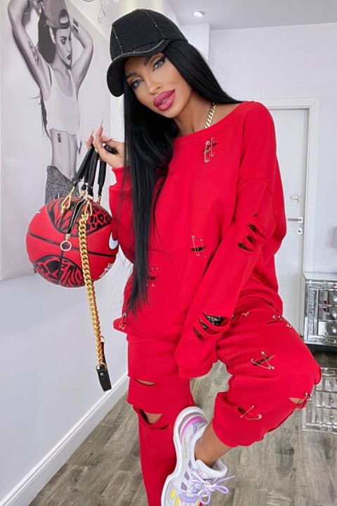 Red 2-piece set, consisting of oversized blouse and trousers with elastic at the ankles. Model with cuts across the entire surface.
