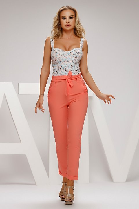 Orange casual pants with side pockets. The pants will help you adopt an unmistakable style and look perfect. Model with bow at the waist.