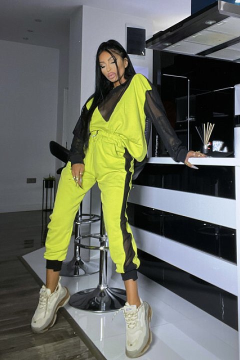 2-piece set with transparent mesh inserts, consisting of blouse with long sleeves and trousers with elastic at the ankles. Fluo yellow model.
