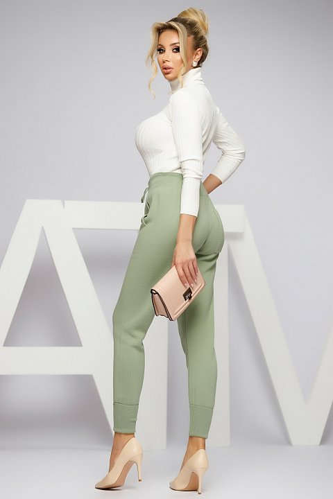Green knitted trousers with a slightly sporty style.