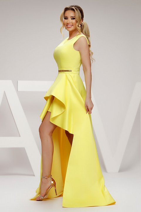 Short yellow dress with pleated train. Model with deep neckline and insert at the waist.