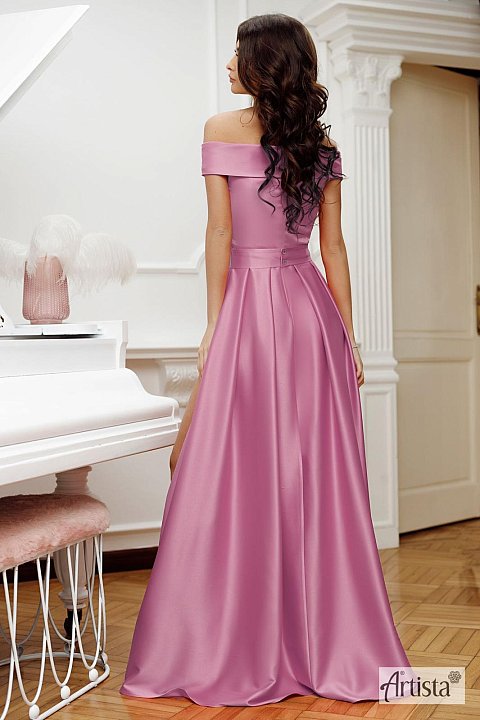 Long dress in pink satin, with slightly dropped shoulders. Model with rhinestone belt at the waist, and deep slit.