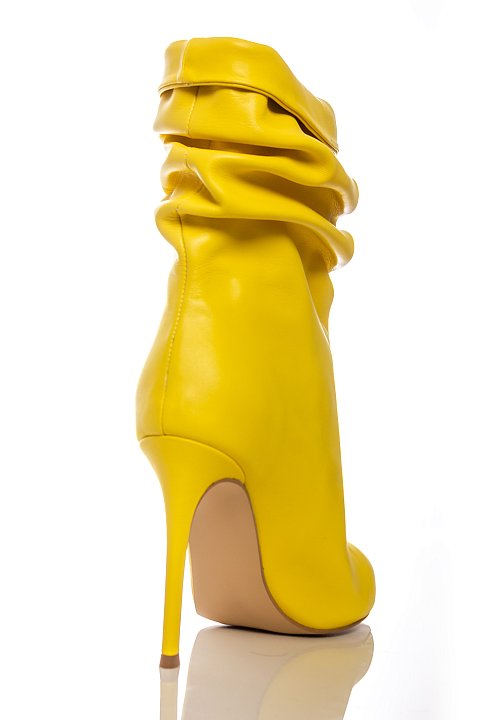 Tronchetto a punta con tacco in similpelle di colore giallo.