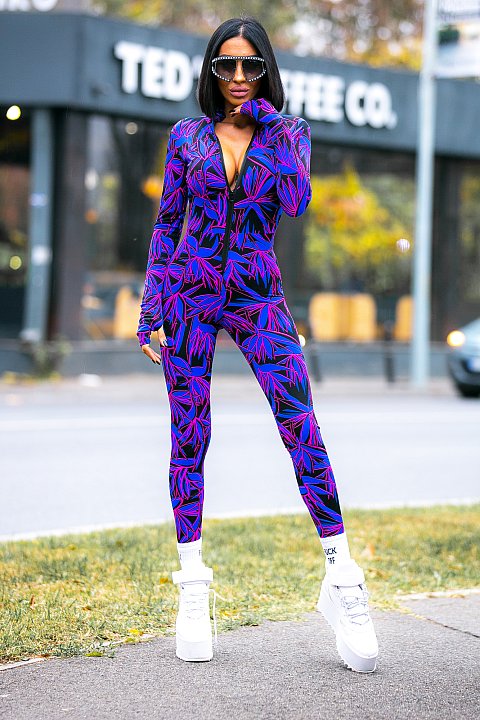One-piece sports suit in purple with tropical print. 